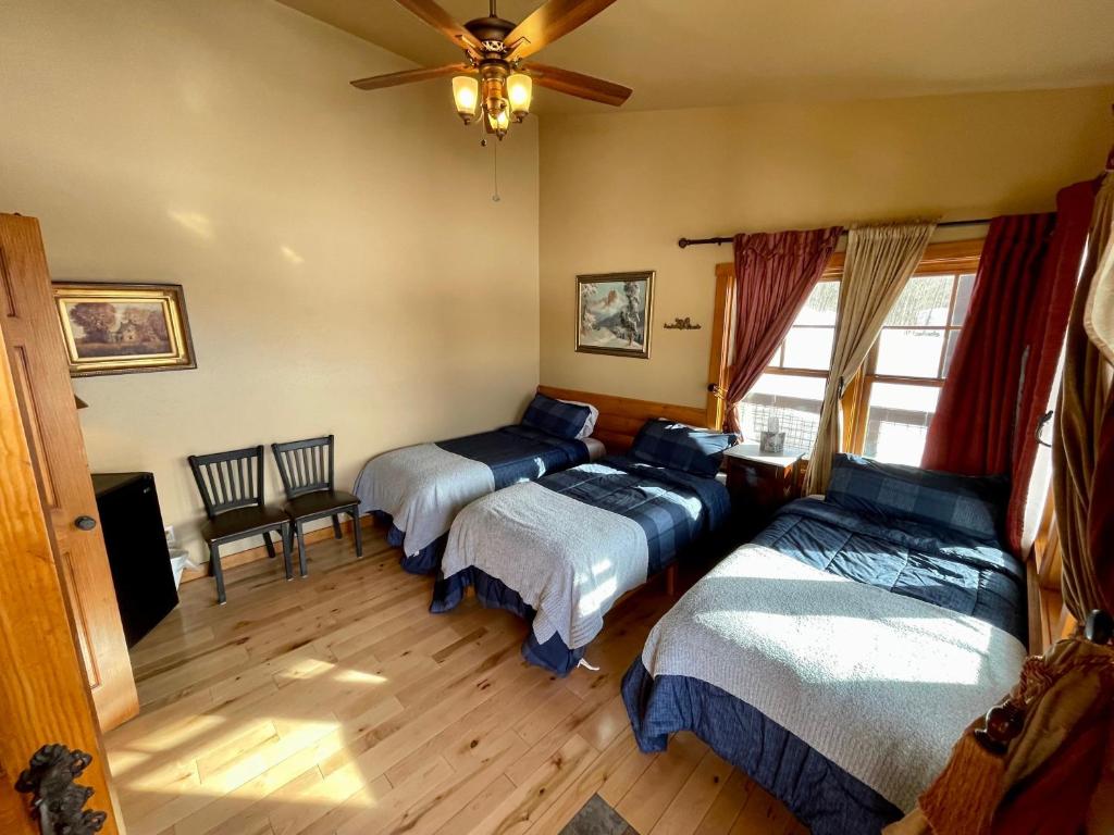 een slaapkamer met 3 bedden en een plafondventilator bij EML 8 Hubbard Park in Paonia