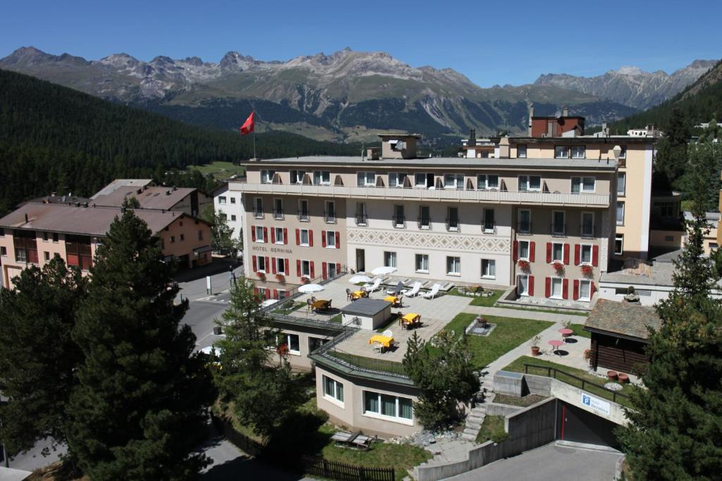 an aerial view of a building with mountains in the background at Hotel Bernina in Pontresina