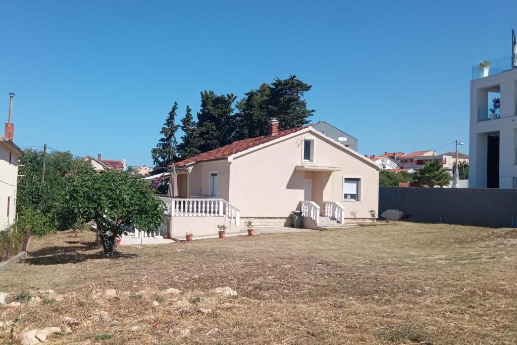 een wit huis met een hek en een tuin bij Seaside house for families with children Zadar - Diklo, Zadar - 20962 in Zadar