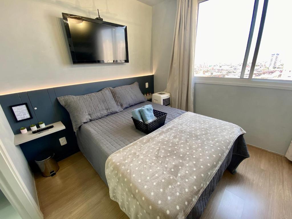 een slaapkamer met een bed en een televisie aan de muur bij Fantástico Apartamento Em Frente Ao Metrô Brás ! in Sao Paulo
