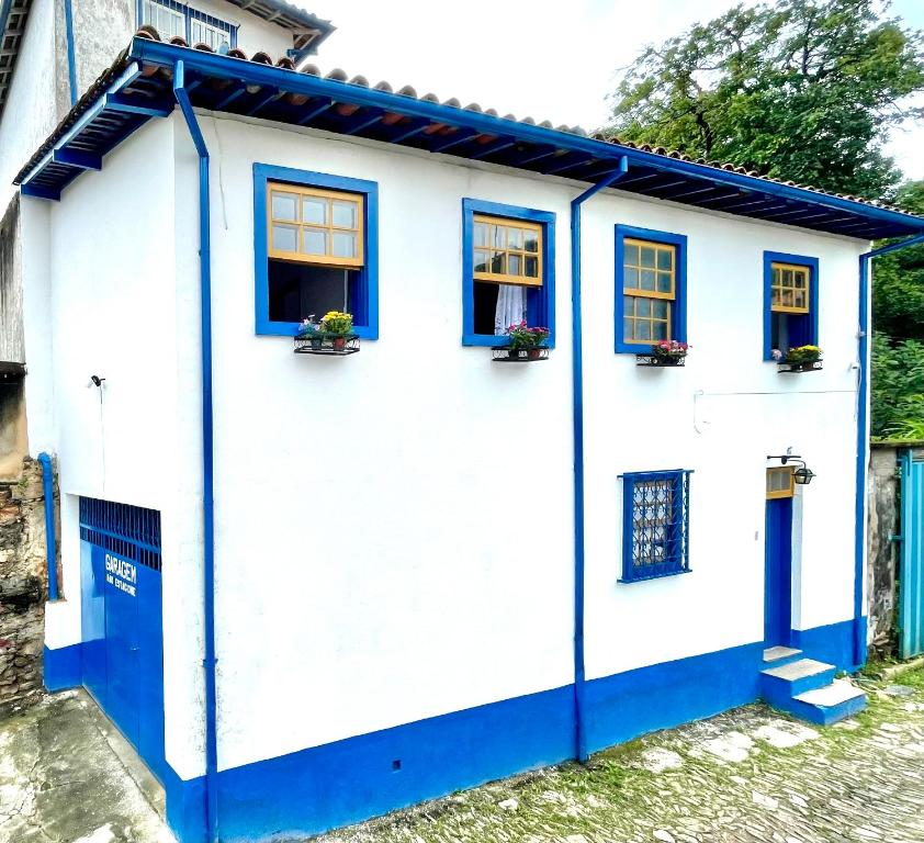 a white and blue house with blue windows at Casa charmosa no Centro Histórico com garagem in Ouro Preto