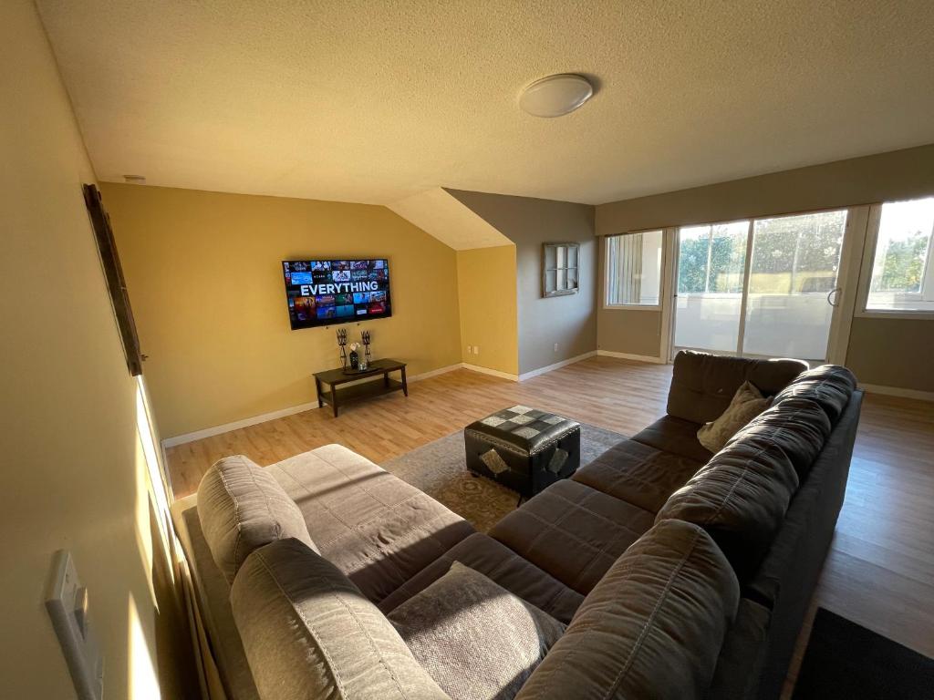 a living room with a couch and a flat screen tv at 3-Bedroom Apartment in 108 Mile Ranch