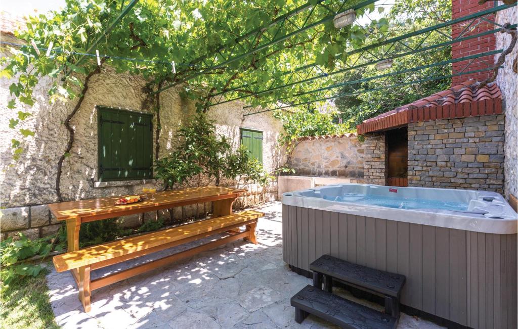 a hot tub in a yard with a bench at Nice Home In Tucepi With 3 Bedrooms, Sauna And Wifi in Tučepi
