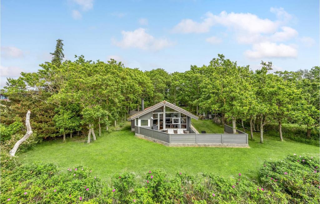 ein Haus auf einem Rasen mit Bäumen im Hintergrund in der Unterkunft Nice Home In Sklskr With House Sea View in Skælskør