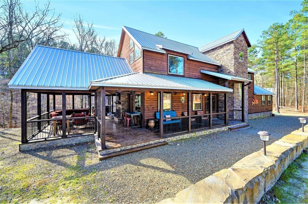 une maison avec un toit en métal et une terrasse dans l'établissement Indian Springs Lodge, à Broken Bow