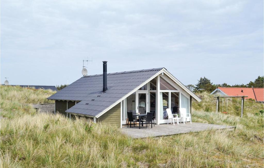 a small house with a porch on a hill at Holiday Home Hvide Sande 41 in Havrvig