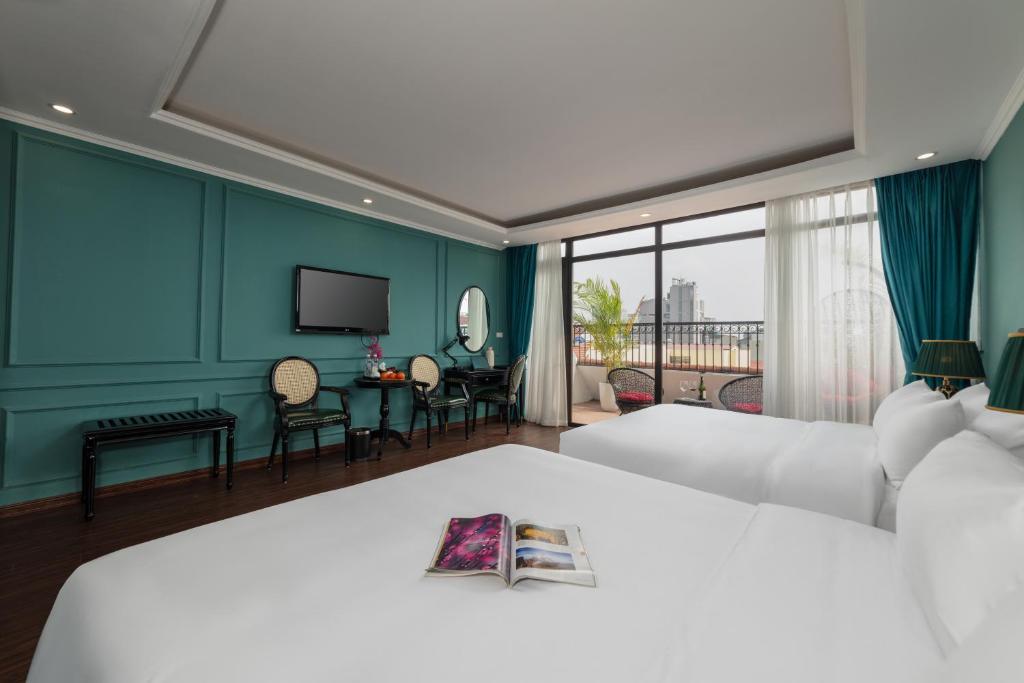 Habitación de hotel con 2 camas y TV en Madelise Palace Hotel & Spa, en Hanói