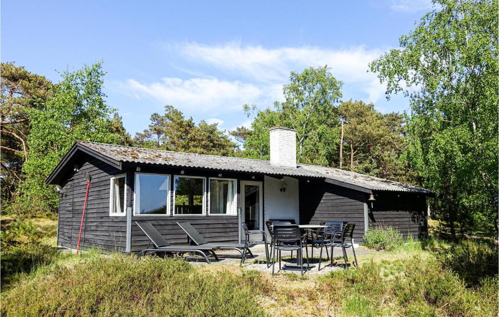 una pequeña casa con sillas y una mesa frente a ella en Gorgeous Home In Nex With Kitchen en Vester Sømarken