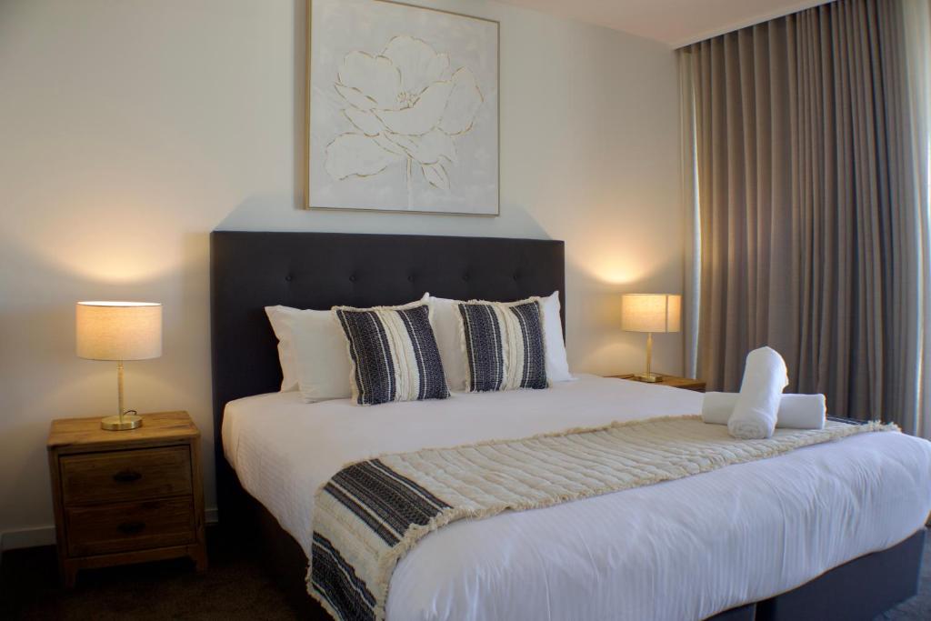 a bedroom with a large bed with white sheets and pillows at RIVERVIEWS@THECOSMOPOLITAN UNIT20805 in Maroochydore