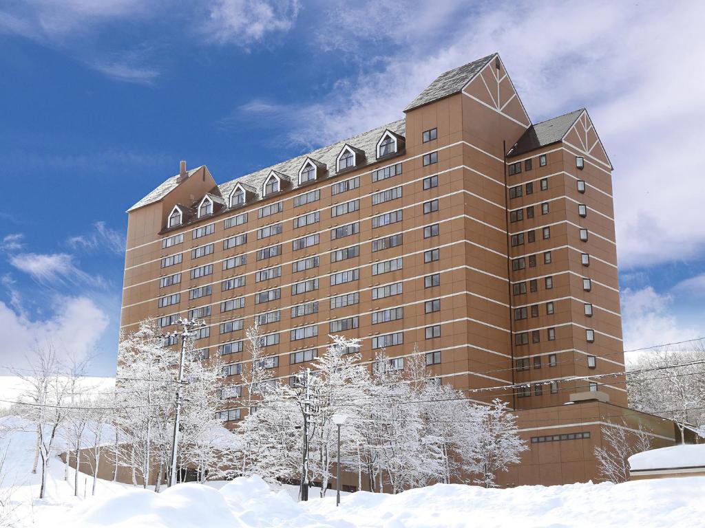 un grand bâtiment avec de la neige devant lui dans l'établissement Holiday Inn Resort Appi Kogen, an IHG Hotel, à Hachimantai