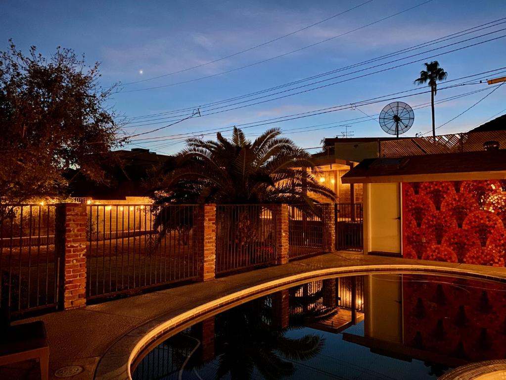 una piscina frente a una casa por la noche en Newer Ranch with Pool and Hot Tub near the Strip and Freemont street. en Las Vegas