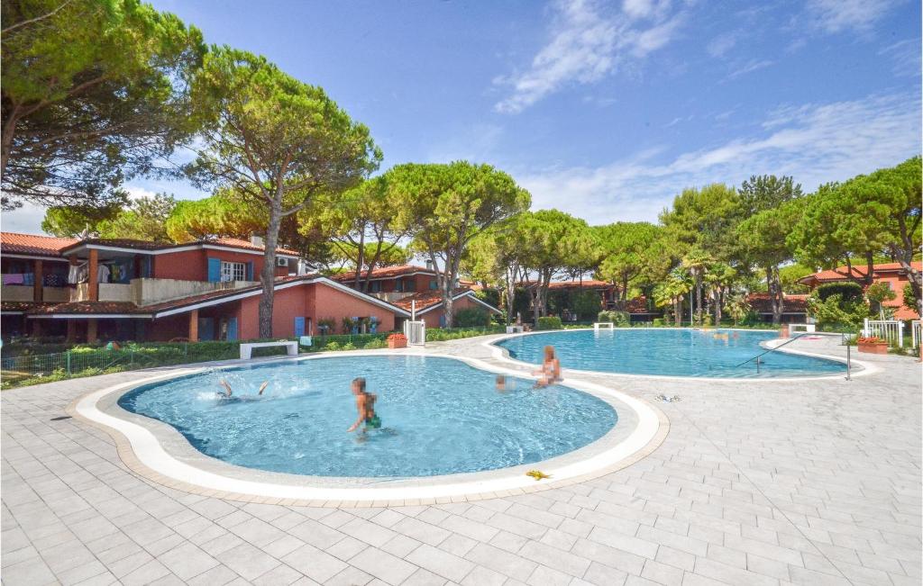 a group of people playing in a swimming pool at Amazing Apartment In Bibione With Outdoor Swimming Pool in Bibione