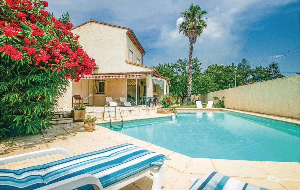 a swimming pool with two chairs and a house at Gorgeous Home In Milhaud With Swimming Pool in Milhaud