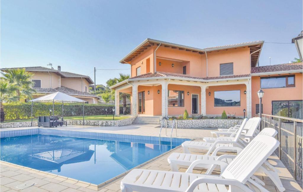 a villa with a swimming pool and white chairs at Villa Del Borgo in Marano Marchesato