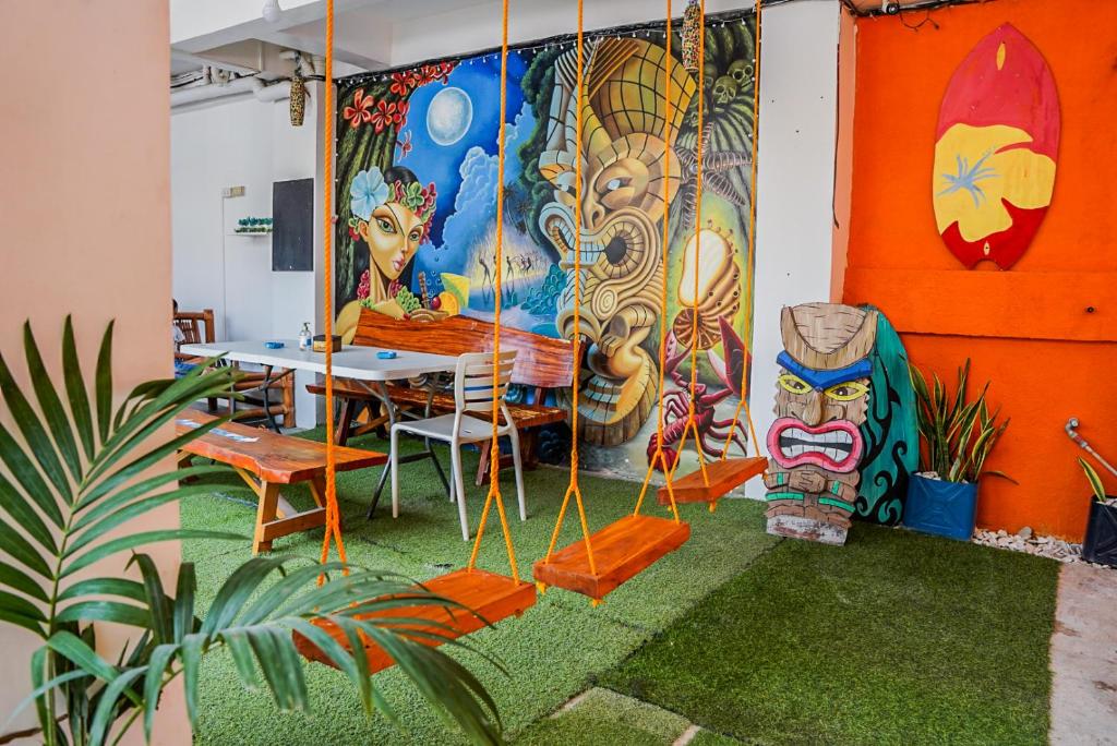 een kamer met een tafel en een muur met schilderijen bij Chill Out Hostel in Boracay