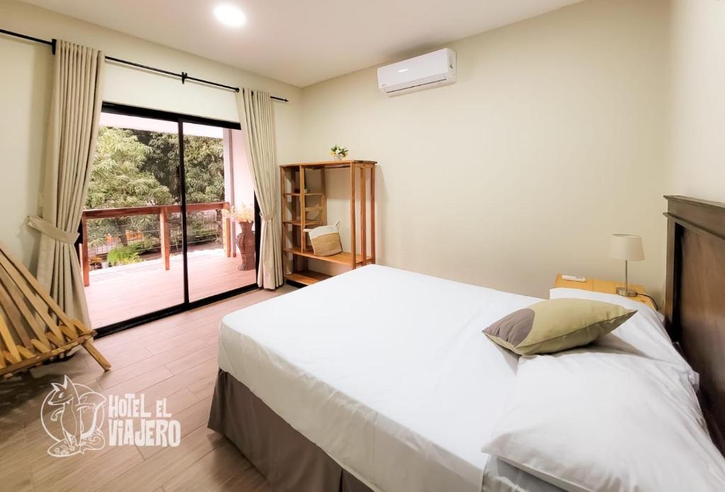 um quarto com uma grande cama branca e uma janela em HOTEL EL VIAJERO em La Libertad