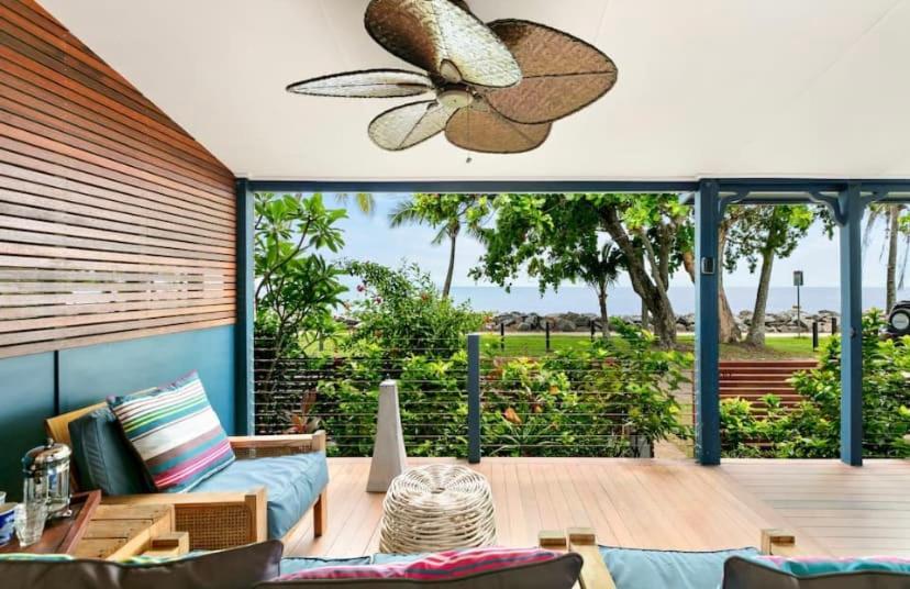 a living room with a patio with a ceiling fan at Villa Oshea - Balinese Beachfront Escape with Pool in Machans Beach