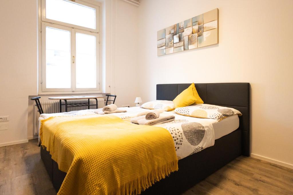 una camera con due letti con lenzuola gialle di Epicenter - rooms & terrace a Lubiana