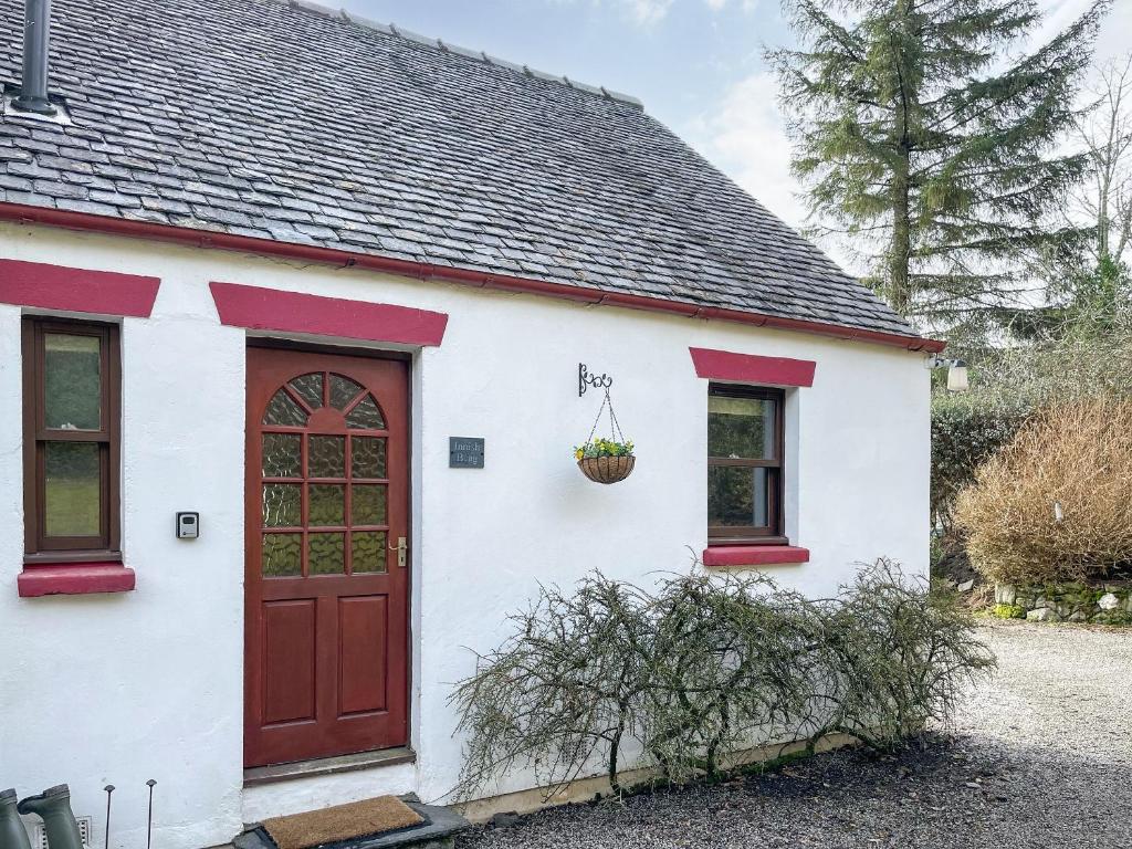 a white and red house with a red door at Innish Beag - Uk38782 in Clachan
