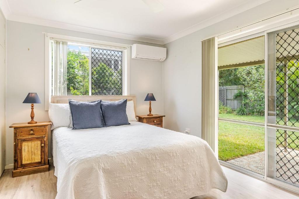 Un dormitorio con una cama y una ventana grande en Seashells - Popular Beach House, en Yamba