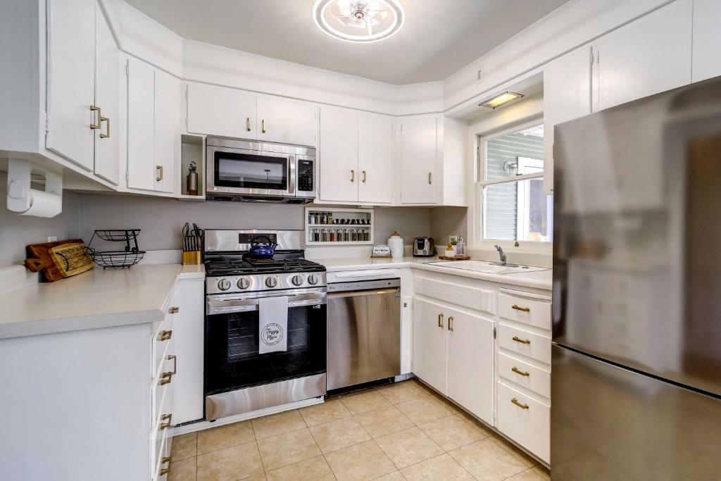 a kitchen with white cabinets and stainless steel appliances at Pet Friendly and Historic Prescott Home with Fire Pit! in Prescott