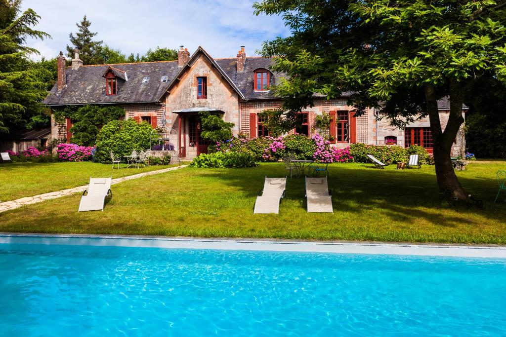 a house with a swimming pool in front of a house at Le Petit Manoir de Kériolet in Concarneau