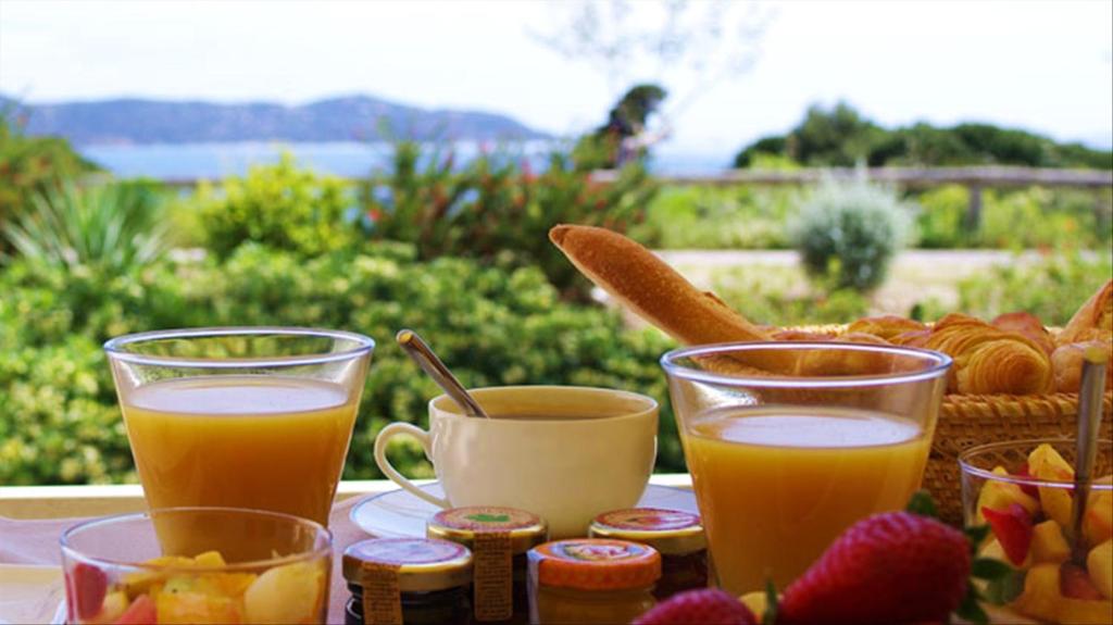 einen Tisch mit zwei Gläsern Orangensaft und einem Korb Brot in der Unterkunft Refresh Boutique Apartments in Vodice