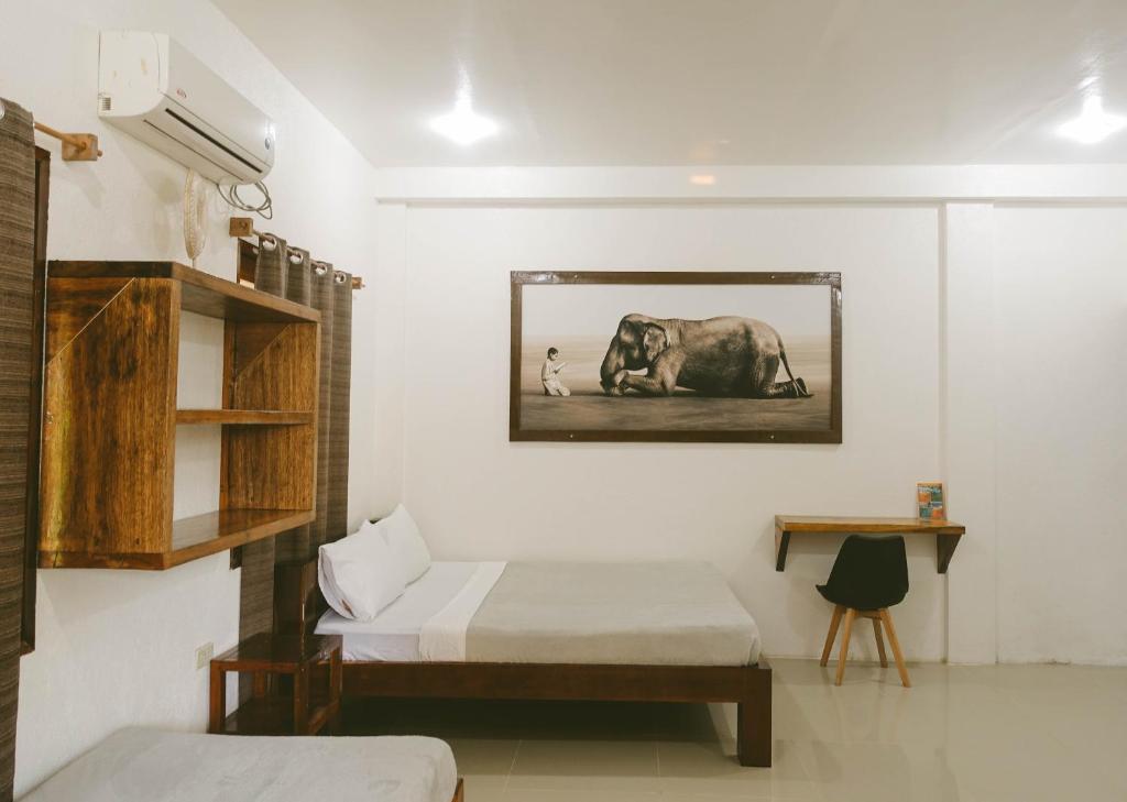 una camera con un letto e una foto di un elefante di Casa De Loren Family Room a General Luna