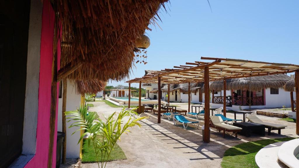 een resort met stoelen, parasols en tafels bij Casa Frida in Chelem