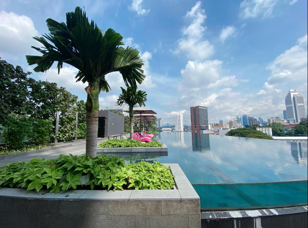 a pool with a palm tree on top of a building at Opus KL Residences by Premium Hospitality in Kuala Lumpur