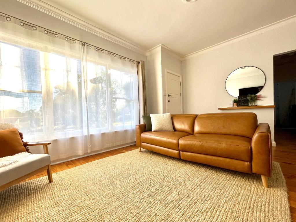 a living room with a couch and a large window at Walnut House Mildura in Mildura