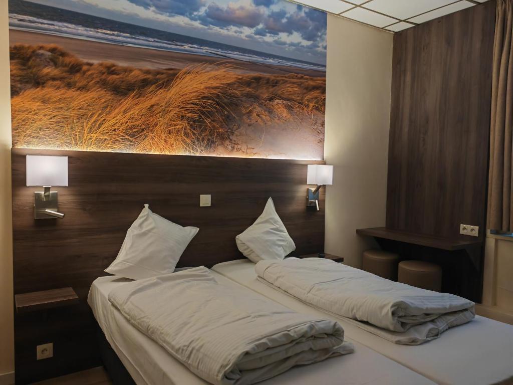 two beds in a hotel room with a painting on the wall at Hotel Albert II Oostende in Ostend