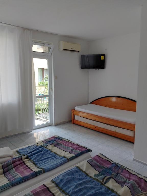 a bedroom with a bed and two carpets on the floor at Lurd Family Hotel in Lozenets