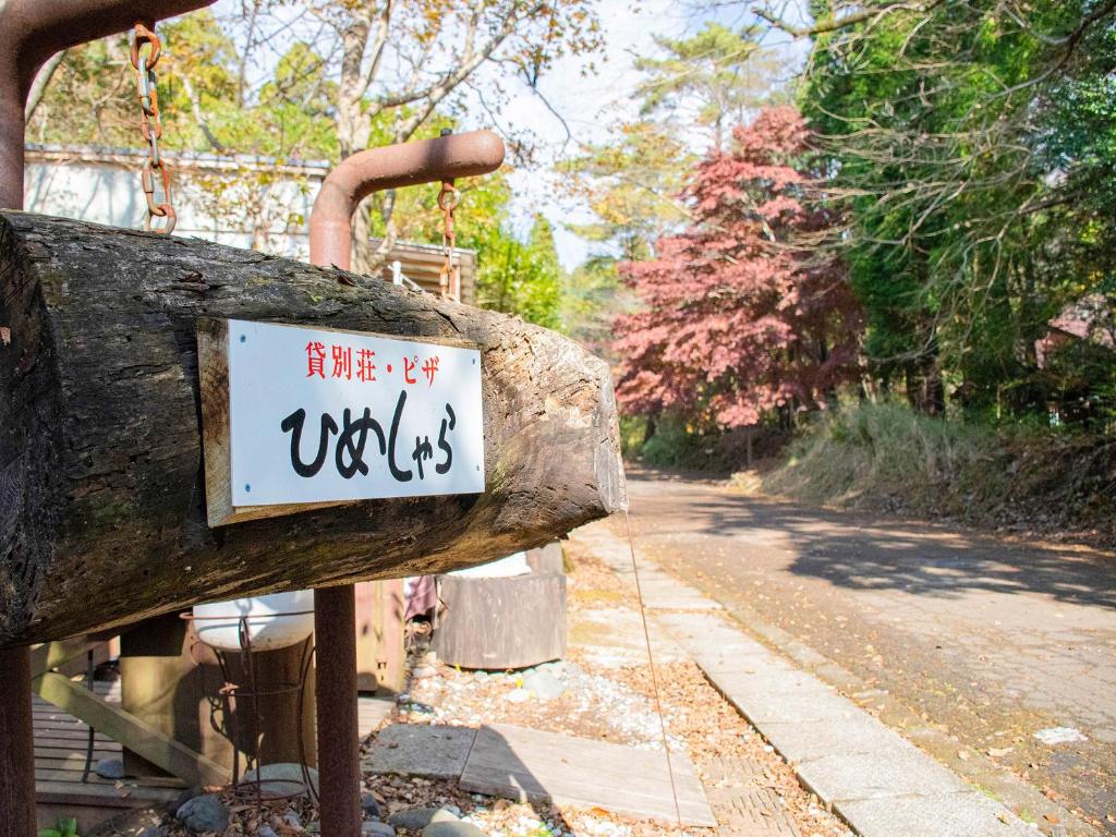 a sign on the side of a log on a road at 貸別荘・グランピングひめしゃら in Kirishima