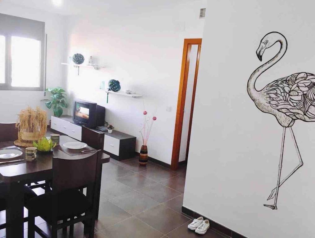 ein Esszimmer mit einer Zeichnung eines Flamingos an der Wand in der Unterkunft Apartamento en el Corazon del Delta in Sant Jaume d’Enveja