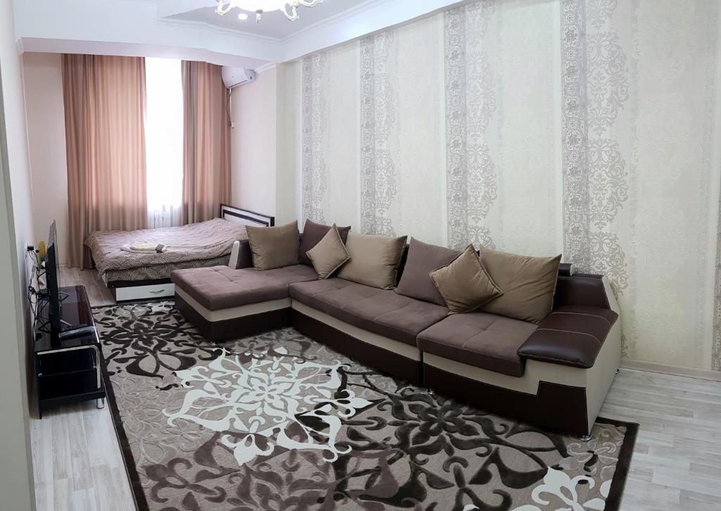 uma sala de estar com um sofá castanho e um tapete em BestBish apartment in the center em Bishkek