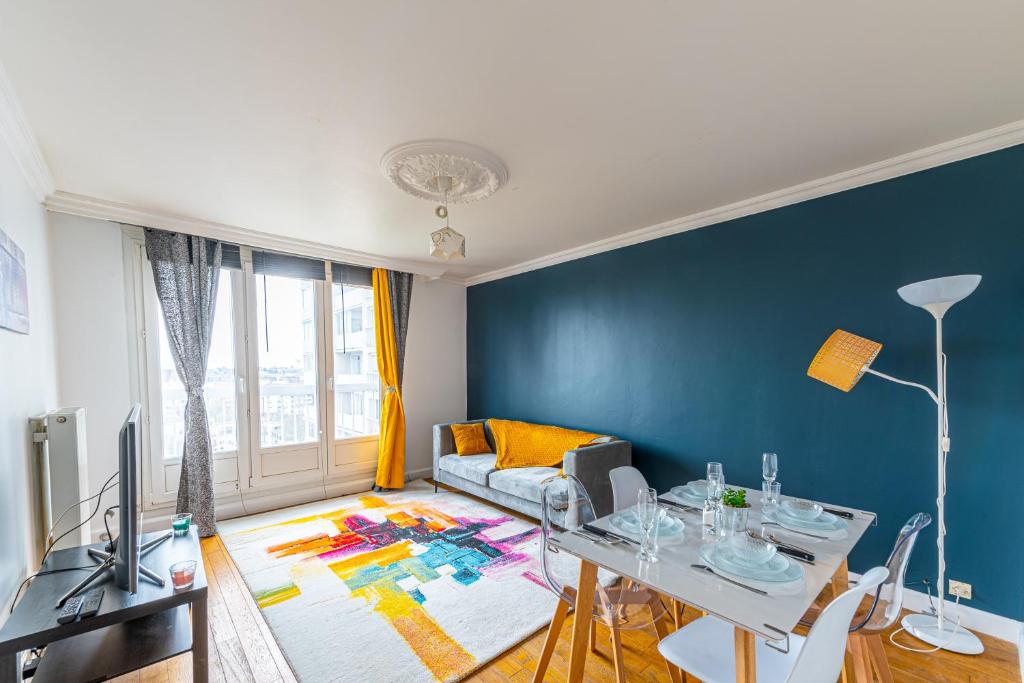 ein Wohnzimmer mit einer Wand mit blauen Akzenten in der Unterkunft Le 4 Richet - Proche Disneyland Paris in Neuilly-sur-Marne