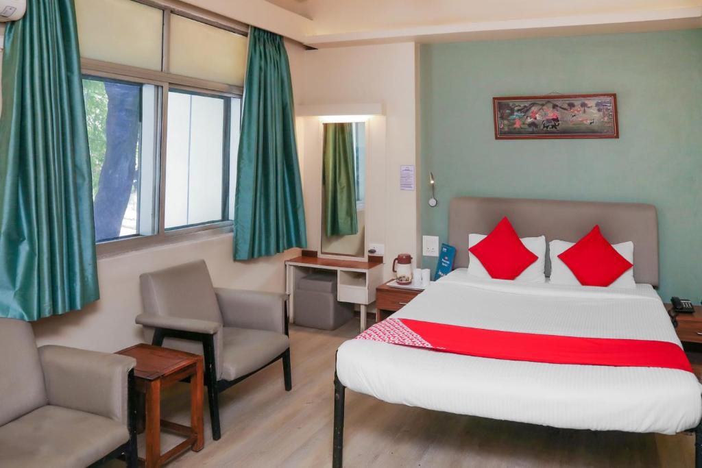 a bedroom with a bed and a desk and a chair at Super Collection O Hotel Pearl Near Shaniwar Wada in Pune