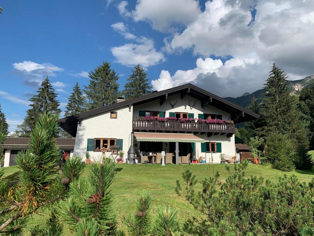 a large house with a balcony on top of a field at Haus Fremerey in Krün