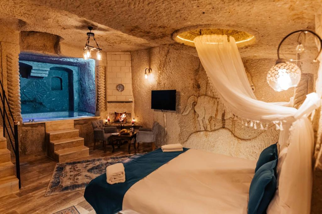 1 dormitorio con 1 cama con cortina y mesa en Bayar Cave Suites, en Ürgüp