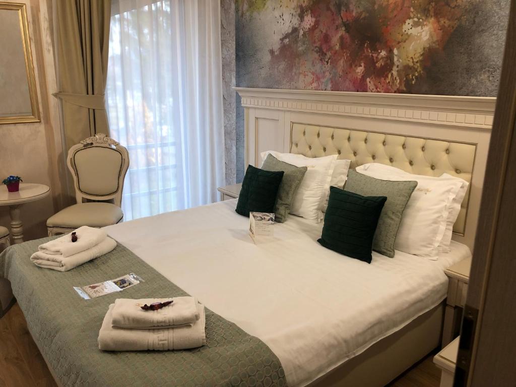 a bedroom with a large bed with towels on it at Park Luxury Rooms in Predeal
