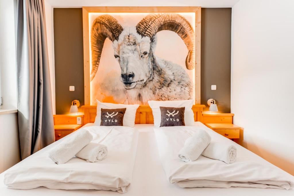 um quarto com uma cama com uma pintura de uma cabra em VYLD: Bad Hindelang inmitten der Berge em Bad Hindelang