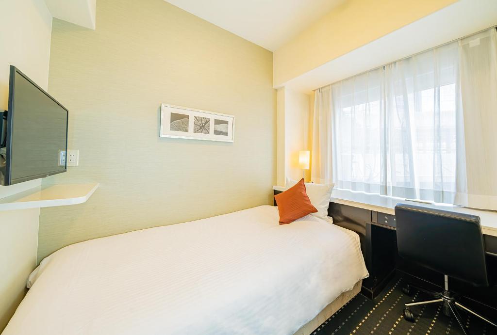 Un pat sau paturi într-o cameră la Kanda Station Hotel