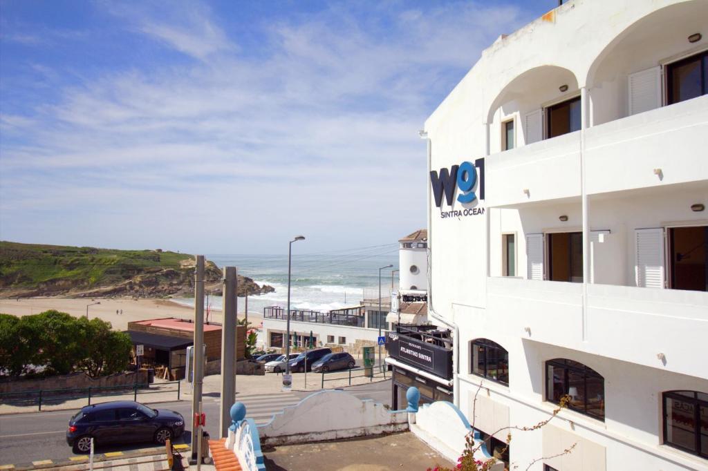 a white building with a view of the beach at WOT Sintra Ocean in Sintra