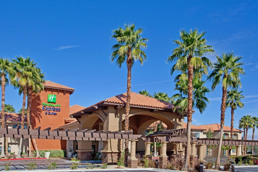 a hotel with palm trees in front of it at Holiday Inn Express & Suites Rancho Mirage - Palm Spgs Area, an IHG Hotel in Rancho Mirage