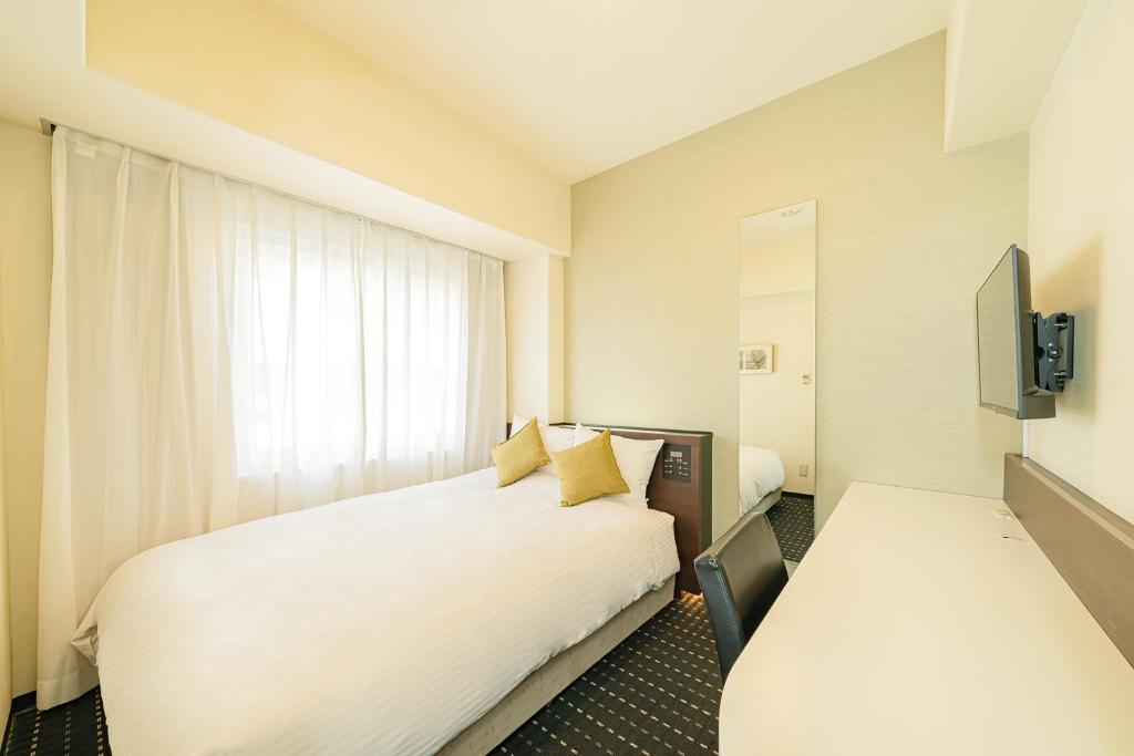 Postel nebo postele na pokoji v ubytování Kanda Station Hotel