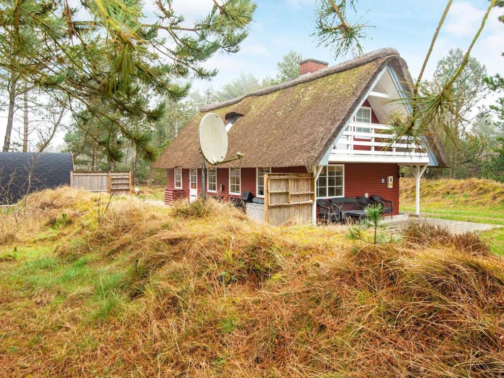 une petite maison au sommet d'une colline herbeuse dans l'établissement Modern Holiday Home in Rømø with Sauna, à Toftum