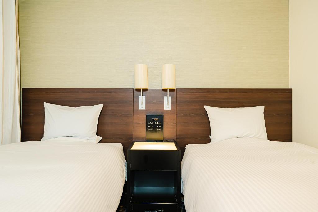 Postel nebo postele na pokoji v ubytování Kanda Station Hotel