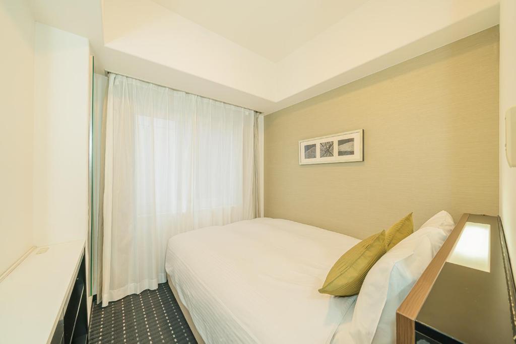 Postel nebo postele na pokoji v ubytování Kanda Station Hotel