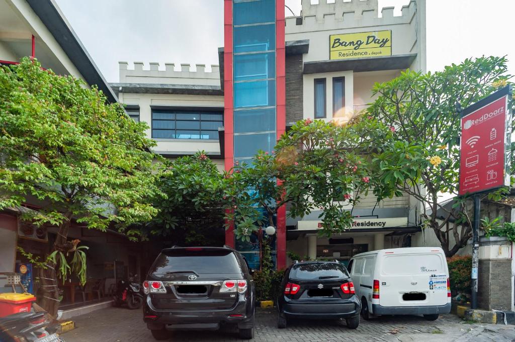 a group of cars parked in front of a building at RedDoorz Plus near Universitas Indonesia in Jakarta